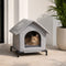 Abri pour chat extérieur gris avec toit souple et base surélevée, placé sur une terrasse lumineuse avec un chat roux à l’intérieur
