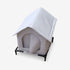 Abri pour chat extérieur en tissu blanc, présenté sur fond blanc et surélevé sur pieds, avec entrée fermée conçue pour protéger le chat des intempéries.