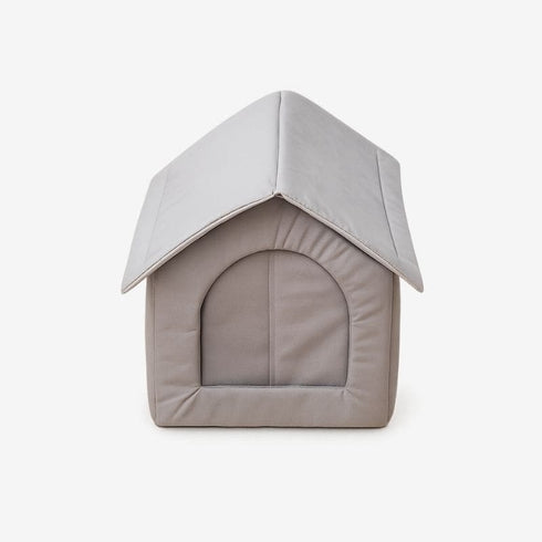 Abri pour chat extérieur en tissu gris, vue de face sur fond blanc, avec entrée fermée et structure protectrice conçue pour offrir un refuge confortable.