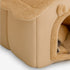 Gros plan sur le tissu doux et les finitions moelleuses d’une cabane intérieure beige pour chat avec entrée rembourrée et toit confortable