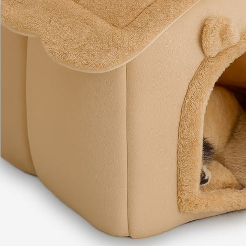 Gros plan d’une cabane pour chat intérieur en peluche beige, entrée et texture du tissu