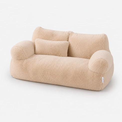 Canapé pour chat beige en peluche douce avec coussin assorti, couchage moelleux et élégant sur fond studio épuré.