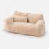 Canapé pour chat beige en peluche douce avec coussin assorti, couchage moelleux et élégant sur fond studio épuré.