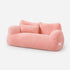 Canapé pour chat rose en peluche douce avec coussin assorti, couchage moelleux et élégant sur fond studio épuré.