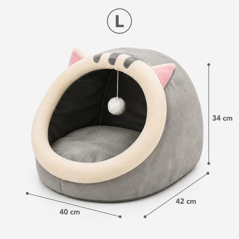 Cocon pour chat gris en peluche avec coussin intégré, oreilles décoratives et pompon suspendu, dimensions taille L indiquées sur l’image.