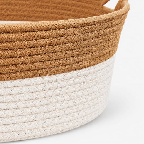 Gros plan sur une corbeille osier pour chat imitation osier beige et blanc avec texture tressée et finitions soignées.
