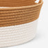 Gros plan sur une corbeille osier pour chat imitation osier beige et blanc avec texture tressée et finitions soignées.