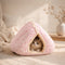 Chat blanc allongé dans un coussin anti-stress rose à motifs floraux avec intérieur ultra doux, posé dans une chambre cosy et lumineuse.
