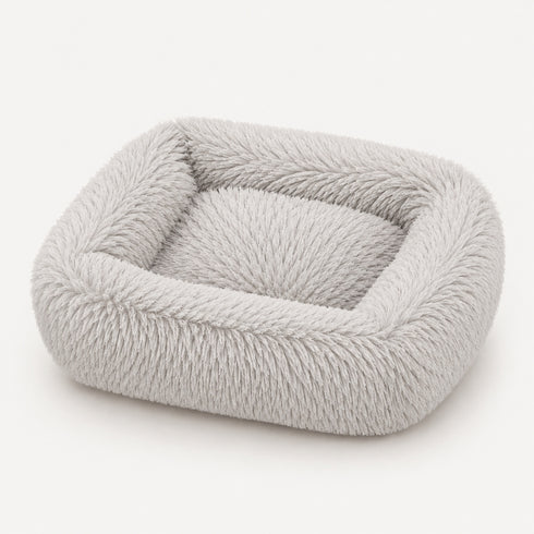 Coussin apaisant rectangulaire pour chat en tissu ultra moelleux gris clair, présenté sur fond neutre en studio.