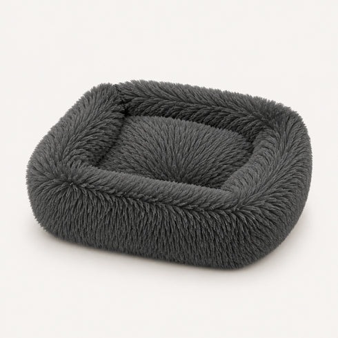 Coussin apaisant rectangulaire pour chat en tissu ultra moelleux gris foncé, présenté sur fond neutre en studio.
