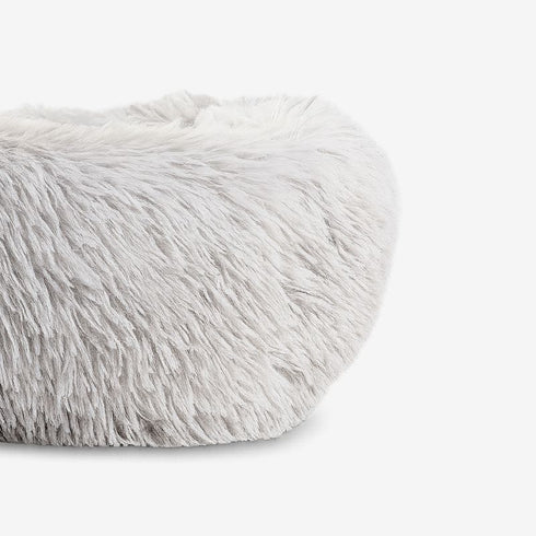 Détail rapproché du coussin apaisant pour chat, montrant la texture douce et longue de la fourrure gris clair.