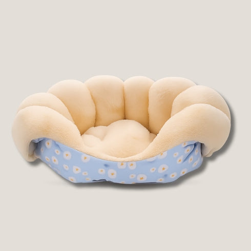 Coussin pour chat anti-stress en velours crème et bleu à motifs fleuris, présenté vide en vue avant sur fond neutre, avec bords épais et moelleux.