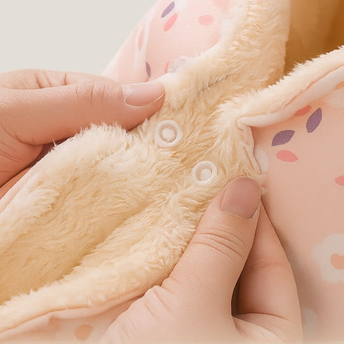 Gros plan sur le coussin pour chat anti-stress en velours crème et rose à motifs pois, montrant les boutons-pression et la doublure douce en fourrure.