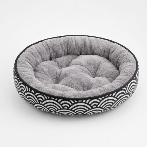 Coussin pour chaton rond en peluche grise avec rebords rembourrés et motif graphique noir et blanc, idéal pour un repos confortable.