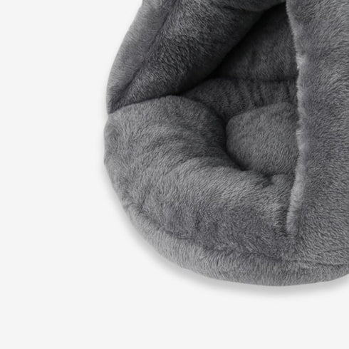Gros plan sur la texture douce et rembourrée d’un coussin chauffant gris pour chat.