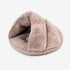 Coussin pour chat chauffant en peluche beige, forme cocon, présenté en studio sur fond blanc, mettant en valeur son design doux et enveloppant