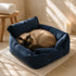 Chat à poils longs allongé dans un coussin moelleux bleu foncé, installé dans une salle de bain chaleureuse avec lumière naturelle et ambiance cocooning.