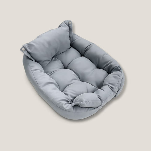Panier pour chat en tissu gris, coussin moelleux avec dossier relevé et bords rembourrés.