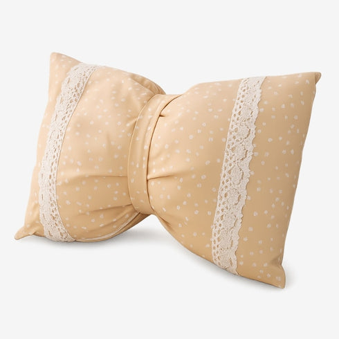 Coussin décoratif en forme de nœud pour lit de chat, tissu beige à pois avec bandes de dentelle, présenté seul sur fond blanc.