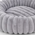 Gros plan d’un coussin rond pour chat gris en peluche ultra douce, mettant en valeur les reliefs rembourrés et la texture moelleuse du couchage.