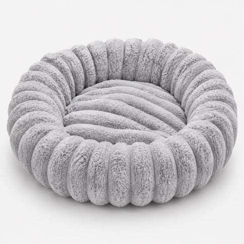 Vue du coussin rond pour chat en tissu duveteux gris lavande, forme cocon circulaire confortable.