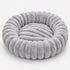 Vue du coussin rond pour chat en tissu duveteux gris lavande, forme cocon circulaire confortable.