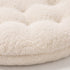Gros plan sur la texture ultra douce en tissu bouclette d’un coussin pour panier pour chat beige avec rembourrage moelleux et finitions confortables.