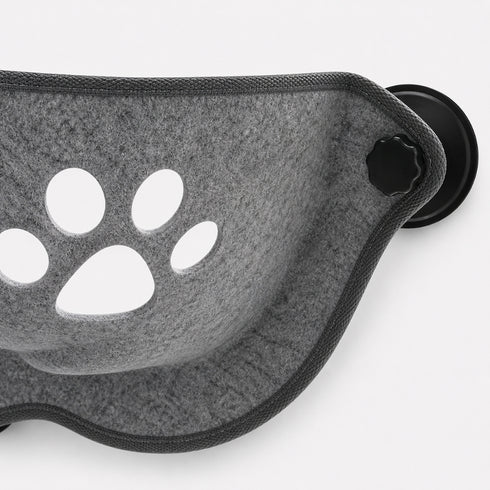 Détail du panier pour chat en hauteur en feutre gris avec fixation par ventouse renforcée et motif patte de chat ajouré.