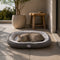 Grand lit pour chat gris avec coussin moelleux blanc, installé sur une terrasse lumineuse avec un chat allongé confortablement.