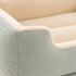 Gros plan sur un grand panier chat vert avec revetement doux et interieur moelleux creme mettant en avant la texture et le confort du couchage