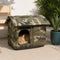 Grande maison pour chat extérieur camouflage avec toit rembourré, installée sur une terrasse avec un chat roux à l’intérieur