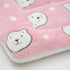 Gros plan sur un petit tapis pour chat rose en peluche douce avec motifs têtes de chat et finition moelleuse sur fond clair