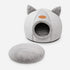 Grotte pour chat grise avec oreilles décoratives et coussin amovible assorti, présentée sur fond clair en photo produit