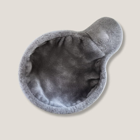 Hamac pour arbre à chat en peluche grise, de forme arrondie avec rebords doux, présenté seul en photo studio sur fond neutre