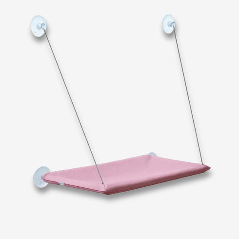 Hamac de fenêtre pour chat en tissu rose, maintenu par ventouses et câbles, présenté seul sur fond blanc pour montrer la surface de repos suspendue