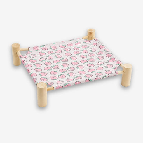 Hamac pour chat sur pied avec structure en bois naturel et toile rose à motifs fraises offrant un espace de repos confortable et original pour chat.