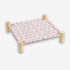 Hamac pour chat sur pied avec structure en bois naturel et toile rose à motifs fraises offrant un espace de repos confortable et original pour chat.