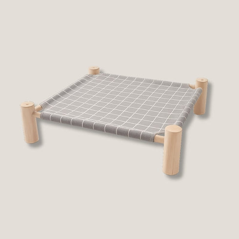 Hamac pour chat sur pied en bois clair avec toile grise quadrillée, présenté seul en photo studio sur fond neutre, sans mise en situation.