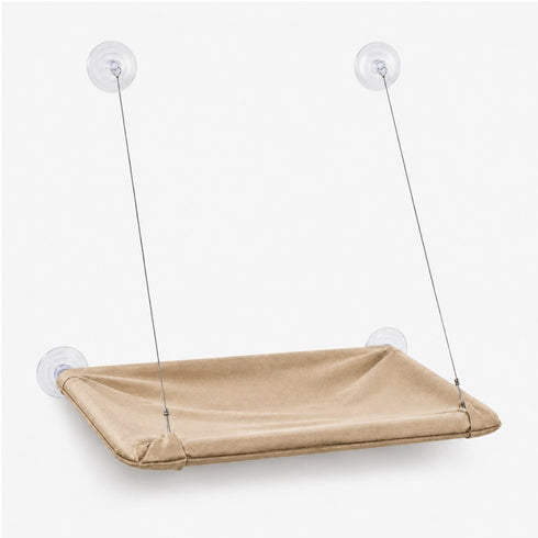 Hamac de fenêtre pour chat beige suspendu avec ventouses transparentes et câbles métalliques, présenté sur fond neutre en studio.