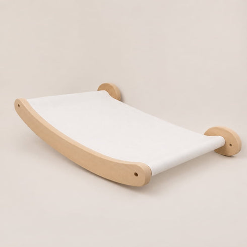 Hamac mural pour chat en bois clair avec toile blanche suspendue, conçu pour offrir un espace repos minimaliste et confortable.