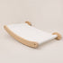 Hamac mural pour chat en bois clair avec toile blanche suspendue, conçu pour offrir un espace repos minimaliste et confortable.