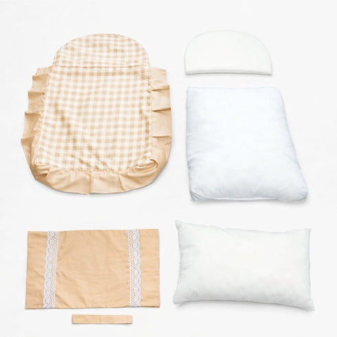 Éléments démontés d’un petit lit pour chat avec housse à carreaux beige, coussins et rembourrage amovibles, présentés sur fond clair.