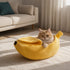 Chat allongé dans un lit banane jaune en peluche douce, couchage original et confortable pour chat d’intérieur.
