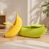 Lit banane pour chat en peluche jaune et verte avec coussin intégré, couchage original et confortable pour intérieur moderne.