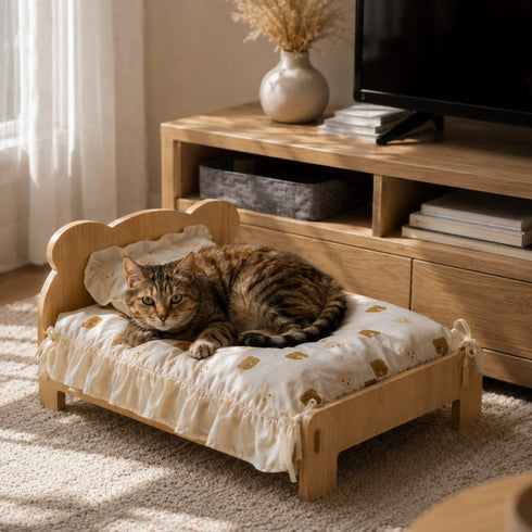 Lit en bois pour chat avec coussin à motifs ours et chat tigré allongé dans un salon chaleureux au style naturel et cosy