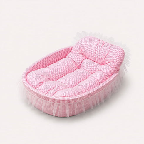 Lit pour chaton rose à carreaux avec coussin moelleux et finition à volants, couchage confortable sur fond studio épuré.