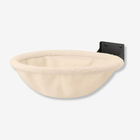 Lit mural pour chat en peluche beige clair, présenté seul en photo studio, avec couchage arrondi et support mural discret.