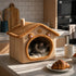 Chat endormi dans une maison pour chat beige avec toit moelleux et détails ourson, posée dans une cuisine lumineuse et chaleureuse.