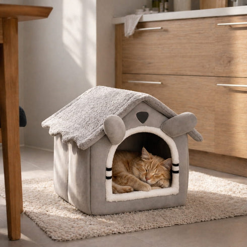 Chat roux endormi dans une maison pour chat grise avec toit moelleux, idéale pour offrir un espace de repos confortable et rassurant.