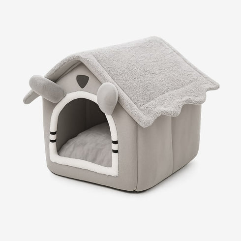 Maison à chat grise en tissu, vue trois-quarts sur fond blanc, avec coussin intérieur.